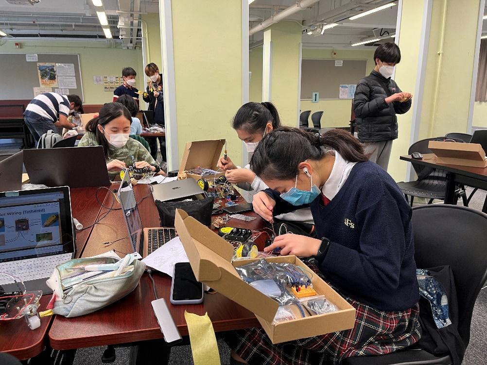 A group of people in a room with computers

Description automatically generated