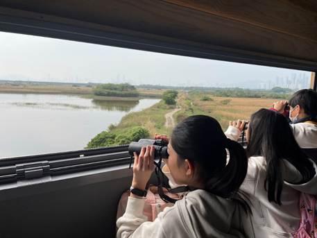 A group of people looking out a window
AI-generated content may be incorrect.